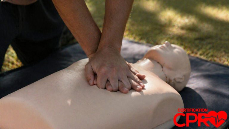 Person performing hands-only CPR on a mannequin outdoors in Durham.